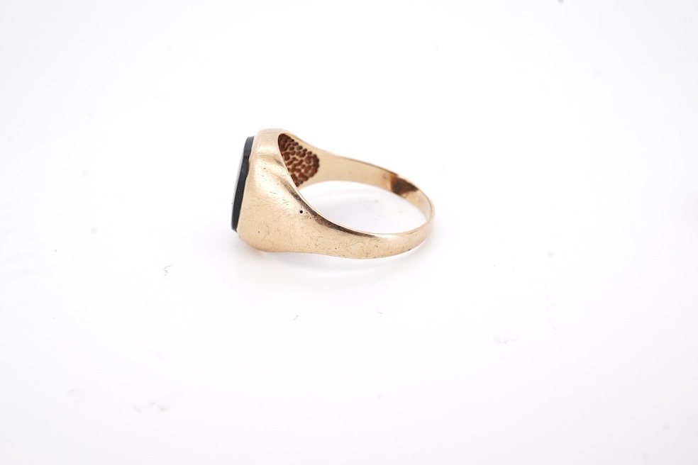 A 1980's 9ct gold tie clip, 39mm and a similar 9ct gold and black onyx set signet ring, gross weight 10 grams.